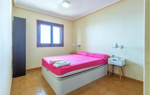 een kleine slaapkamer met een roze bed en een raam bij Beautiful Apartment In Santa Pola With Outdoor Swimming Pool in Santa Pola