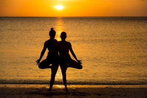 two people standing on the beach watching the sunset at Oasis Yoga Bungalows in Ko Lanta