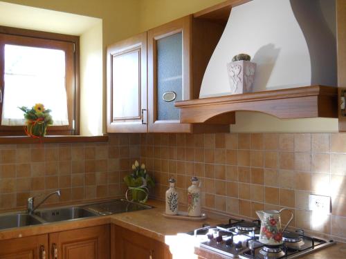 Una cocina con fregadero y estufa y dos ventanas. en Agriturismo Valiana, en Montegabbione