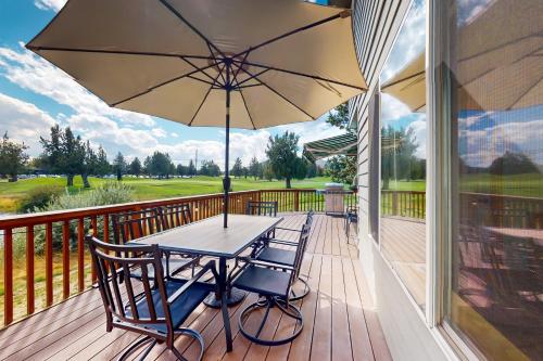 a wooden deck with a table and chairs and an umbrella at The Golden Pheasant in Redmond