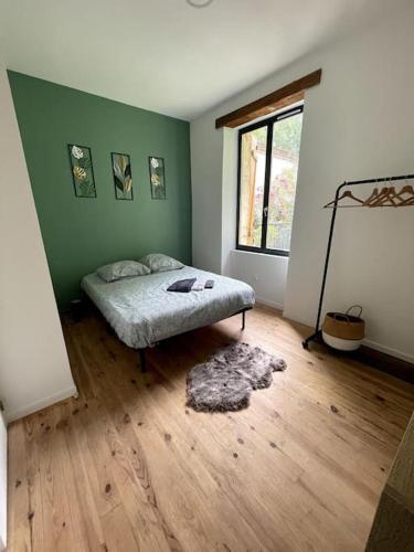 sypialnia z łóżkiem w zielonej ścianie w obiekcie Superbe appartement cosy avec jardin w mieście Nîmes