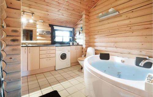 FjerritslevにあるAmazing Home In Fjerritslev With 3 Bedrooms, Sauna And Wifiの木製の壁のバスルーム(バスタブ付)