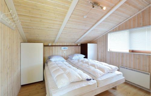 Cama grande en habitación con paredes de madera en 3 Bedroom Stunning Home In Ebeltoft, en Ebeltoft