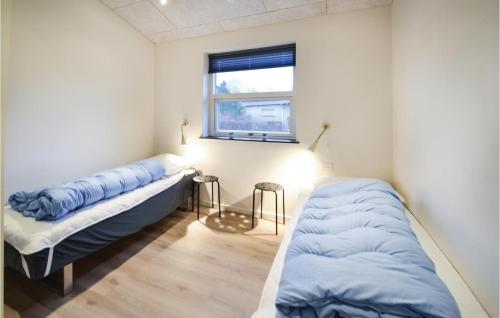 エーベルトフトにあるNice Home In Ebeltoft With 5 Bedrooms, Jacuzzi And Wifiのベッド2台と窓が備わる客室です。