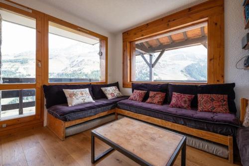 un salon avec un canapé et une table dans l'établissement L'Arc-en-Ciel - Appartement sur les hauteurs du Mottaret avec accès aux pistes, à Les Allues