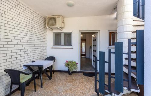 a patio with a table and chairs and a building at 2 Bedroom Amazing Apartment In Malinska in Malinska