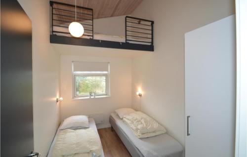 Bøstrupにある3 Bedroom Nice Home In Hjslevのベッド2台と窓が備わる小さな客室です。