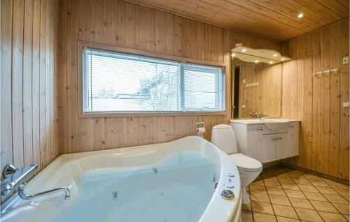 a bathroom with a white tub and a toilet at Awesome Home In Ebeltoft With 3 Bedrooms And Sauna in Ebeltoft