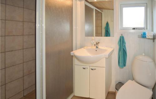 a bathroom with a sink and a shower and a toilet at Jydehuset in Slettestrand