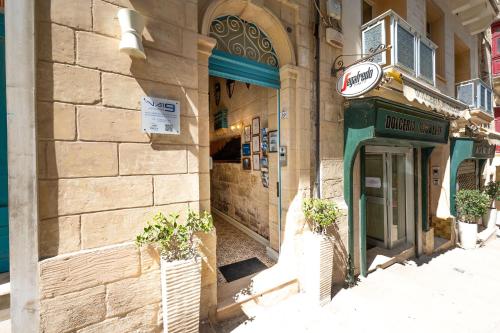 a building with two potted plants in front of it at Valletta Apartments 19 in Valletta