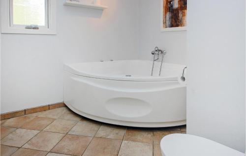 bagno con vasca bianca e pavimento piastrellato di Amazing Home In Haderslev With Kitchen ad Årøsund