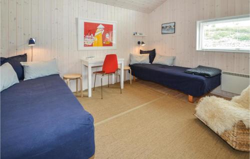 エーベルトフトにあるStunning Home In Ebeltoft With 4 Bedrooms, Sauna And Wifiのベッドルーム1室(ベッド2台、デスク、テーブル付)