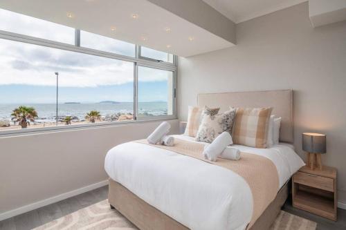 a bedroom with a large bed and a large window at Seaside Studio in Mouille Point in Cape Town