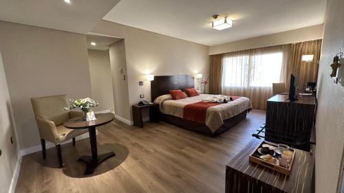 a hotel room with a bed and a table at Land Plaza Hotel in Bahía Blanca