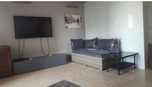 sala de estar con sofá y TV de pantalla plana en Terrasse vue mer, plage à 100m, 3 pièces, en Tel Aviv