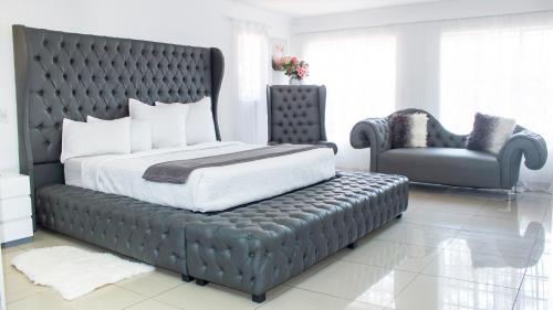 Un dormitorio con una cama grande y una silla. en View Point Self Catering Muldersdrift, en Muldersdrift