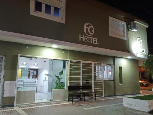 un hôtel avec un banc extérieur la nuit dans l'établissement Hotel FG, à Termas de Río Hondo