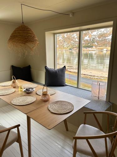 a wooden table in a room with a large window at Casa Lofoten Ramberg Beach Sauna Surfing Kvalvika Reine in Ramberg