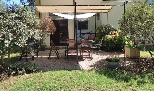 a patio with a table and chairs under an umbrella at B&B Il giardino segreto in Guarda Ferrarese