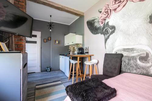 a living room with a cow mural on the wall at Siedlisko Kępina Zdrój in Ostrów