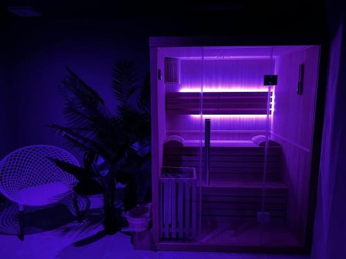 Una habitación con una luz violeta en una habitación. en Scorfel Lodge, Iconic, Spa, sauna & terrasse, en Trégastel