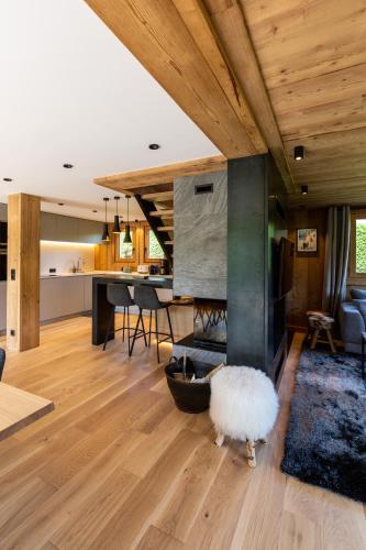 un salon avec cheminée et une cuisine dans l'établissement Megève - Chalet Miage, à Demi-Quartier