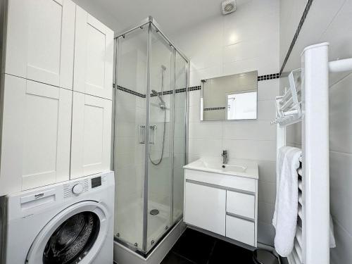 une salle de bain blanche avec une machine à laver et un lavabo dans l'établissement cosy appart - Préfecture Lyon - Servient 1, à Lyon