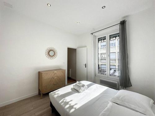 ein weißes Schlafzimmer mit einem Bett und einem Fenster in der Unterkunft cosy appart - Préfecture Lyon - Servient 1 in Lyon