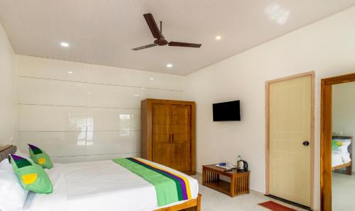 a bedroom with a bed and a ceiling fan at Treebo The Rove, Coorg in Madikeri