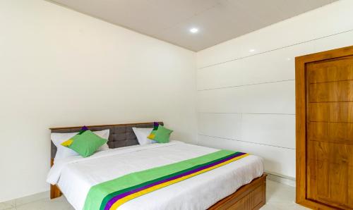a bedroom with a bed with a rainbow blanket on it at Treebo The Rove, Coorg in Madikeri