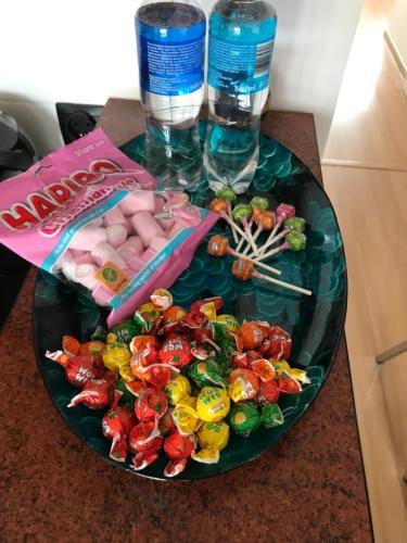 a table with a plate of candy and a bottle of water at Ana 2 Duży przestronny apartament z 2 balkonami Wi-Fi Netflix Idealny dla rodzin z dziećmi in Gorzów Wielkopolski