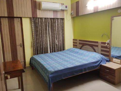 a bedroom with two beds and a mirror and a lamp at Asha vihara Phase-2 in Muzaffarpur