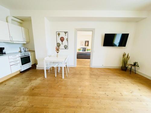 uma cozinha com uma mesa branca e uma bancada branca em aday - Sunshine apartment in the heart og Hjorring em Hjørring