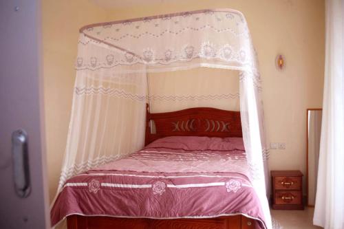 ein Bett mit Baldachin in einem Schlafzimmer in der Unterkunft COSY HOMES SOUTHB in Nairobi