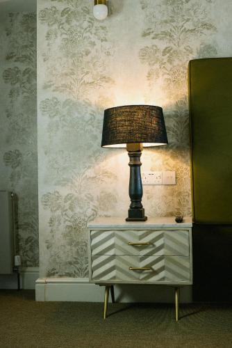 a lamp sitting on top of a dresser in a room at The King's Arms in Dorchester