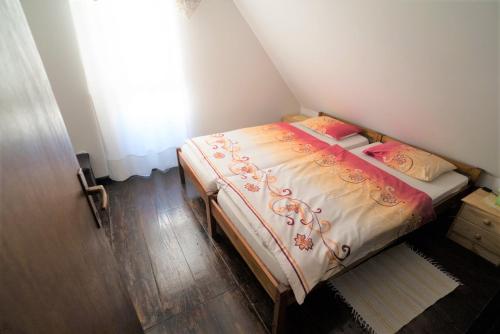 a small bed in a small room with a window at Kmetija Podobnik in Idrija