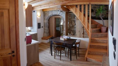 a kitchen and dining room with a table and stairs at La Mizoùn de Marguerito - Appartamento Genziana in Chiappera