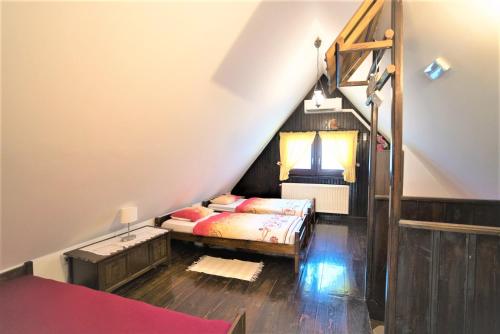 a attic bedroom with a bed and a staircase at Kmetija Podobnik in Idrija
