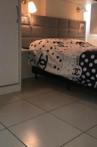 um quarto com uma cama com um cobertor de bolinhas em Apartamento na melhor localização de Recife no Recife