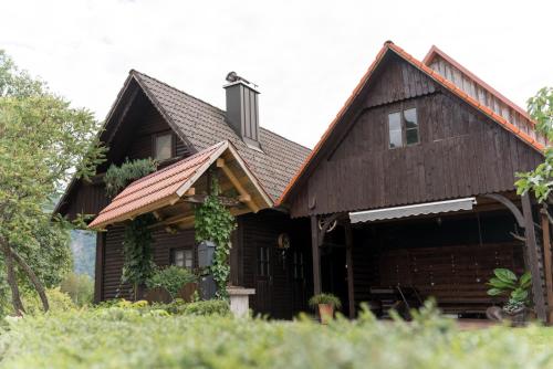a large wooden house with a roof at Kmetija Podobnik in Idrija