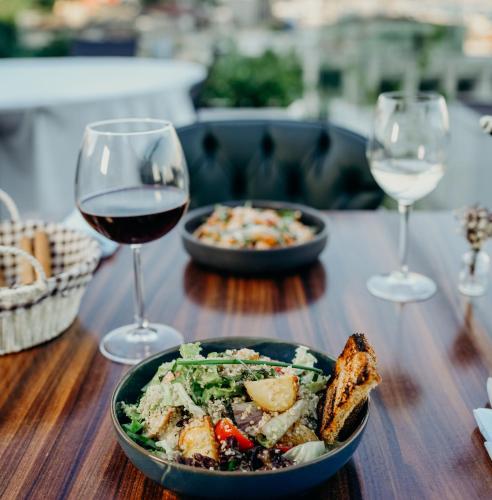 a table with a plate of food and two glasses of wine at Loop Hotel Bosphorus İstanbul in Istanbul