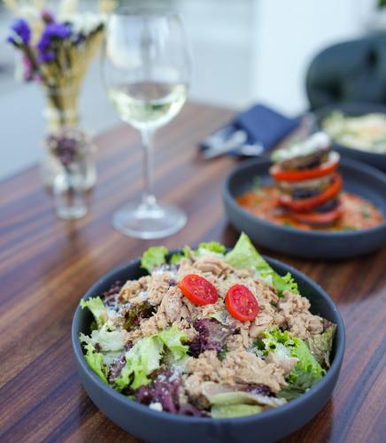 a table with a bowl of salad and a glass of wine at Loop Hotel Bosphorus İstanbul in Istanbul