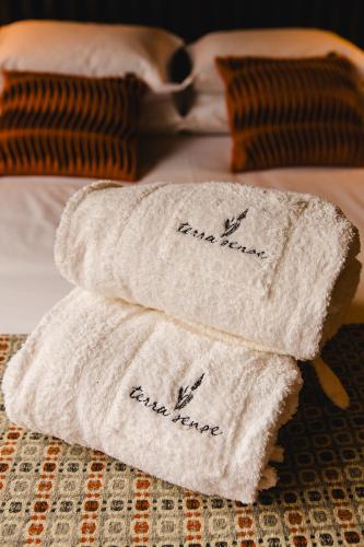 a pile of towels sitting on top of a bed at TerraSense Mountain Charm Retreat & Farm in Videmonte