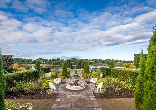 un jardín formal con una fuente y sillas en Lough Rynn Castle 3 bed house, en Mohill