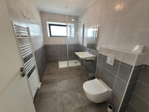 a bathroom with a toilet and a sink at Maison familiale proche plages avec jacuzzi in Tréflez