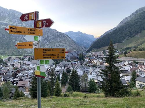 a street sign with many signs in front of a town at Hotel Piz Badus in Andermatt
