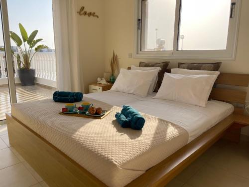 een bed met een dienblad met eten erop bij Nissi Paradise front beach Apt in Ayia Napa