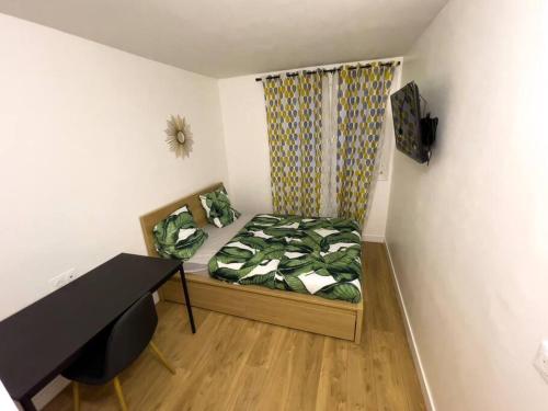 a small room with a bed and a desk at Magnifique appartement de 4 chambres 8 personnes max à 20 minutes de Paris in Antony