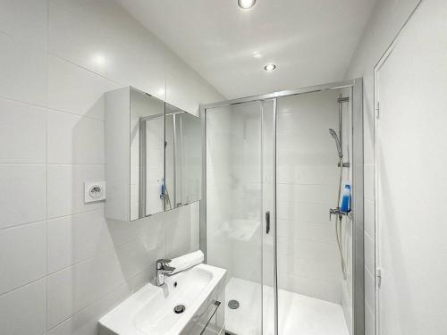 a white bathroom with a shower and a sink at Cosy appt Part Dieu Félix 3 in Lyon