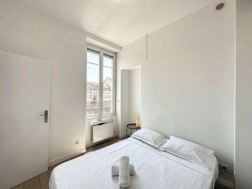 a white bedroom with a bed and a window at Cosy appt Part Dieu Félix 3 in Lyon